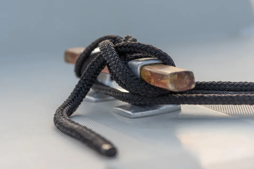 Mooring rope tied around a cleat on a boat deck