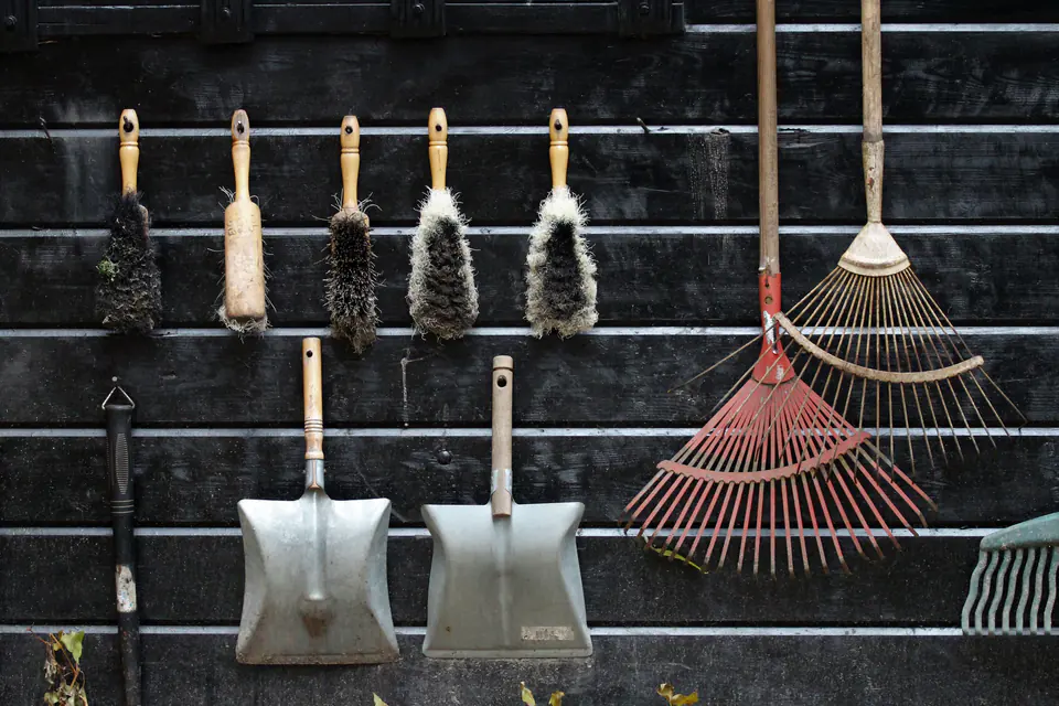 Garden tools hanging on a wooden shed wall